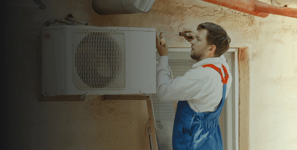 Technician performing HVAC maintenance on a ventilation unit.